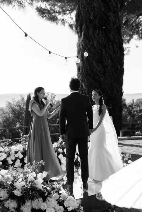 Intimate outdoor ceremony under the trees at Conti di San Bonifacio, surrounded by lush floral arrangements.