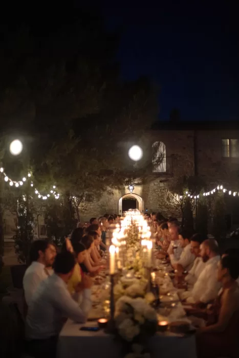 Romantic candlelit al fresco wedding dinner at Conti di San Bonifacio, beneath string lights and trees.