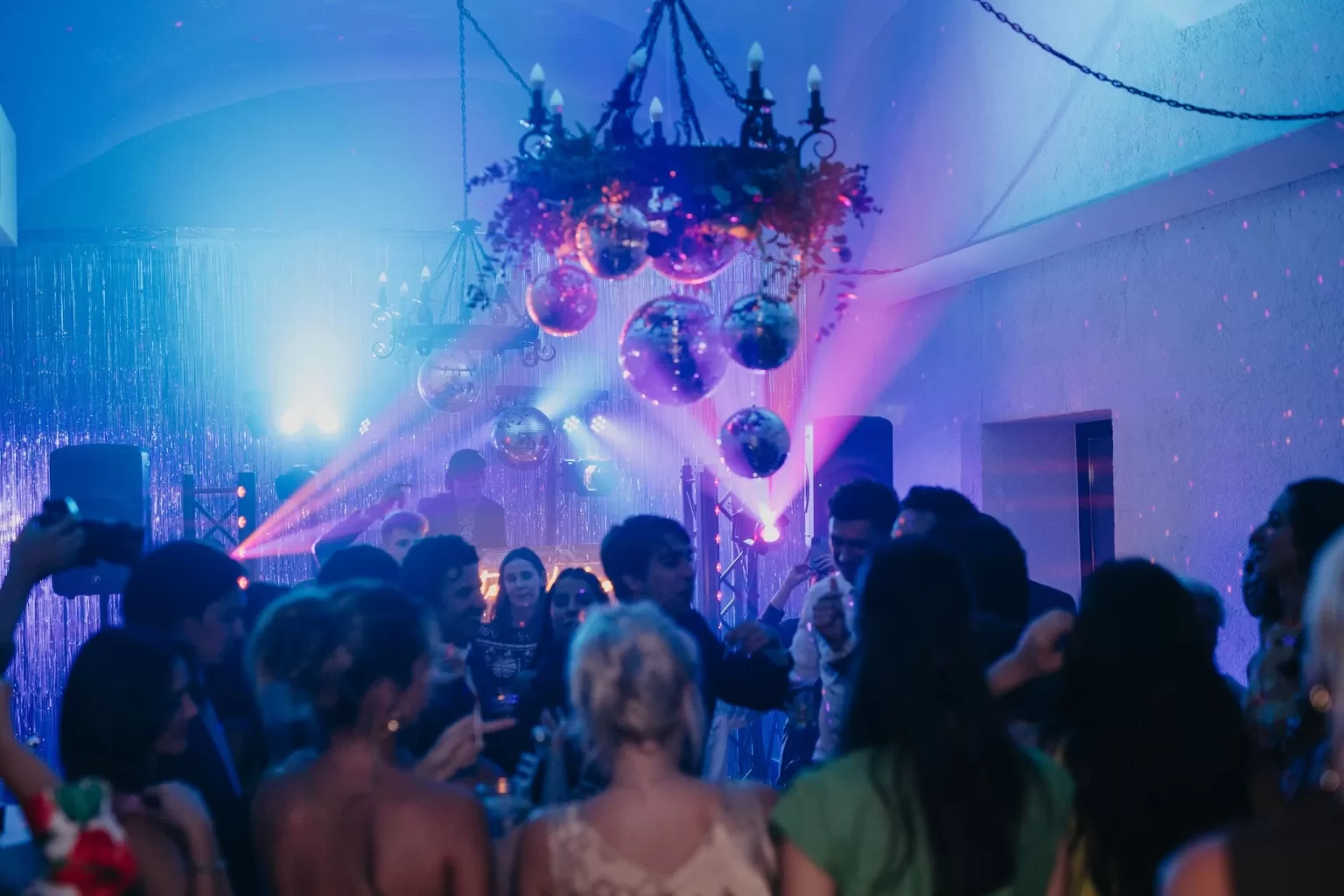 Vibrant indoor wedding party with disco balls and lighting at Finca Es Convent