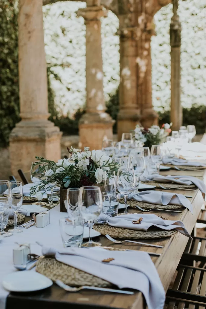 Elegant wedding reception table setting with white flowers and linen napkins at Finca Es Convent.