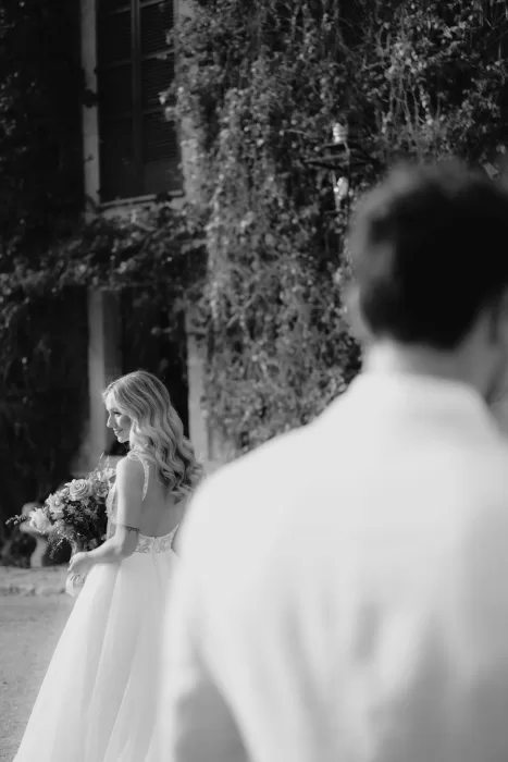 The bride smiles softly as she walks with her bouquet, sunlight catching her hair outside Finca Son Collell.
