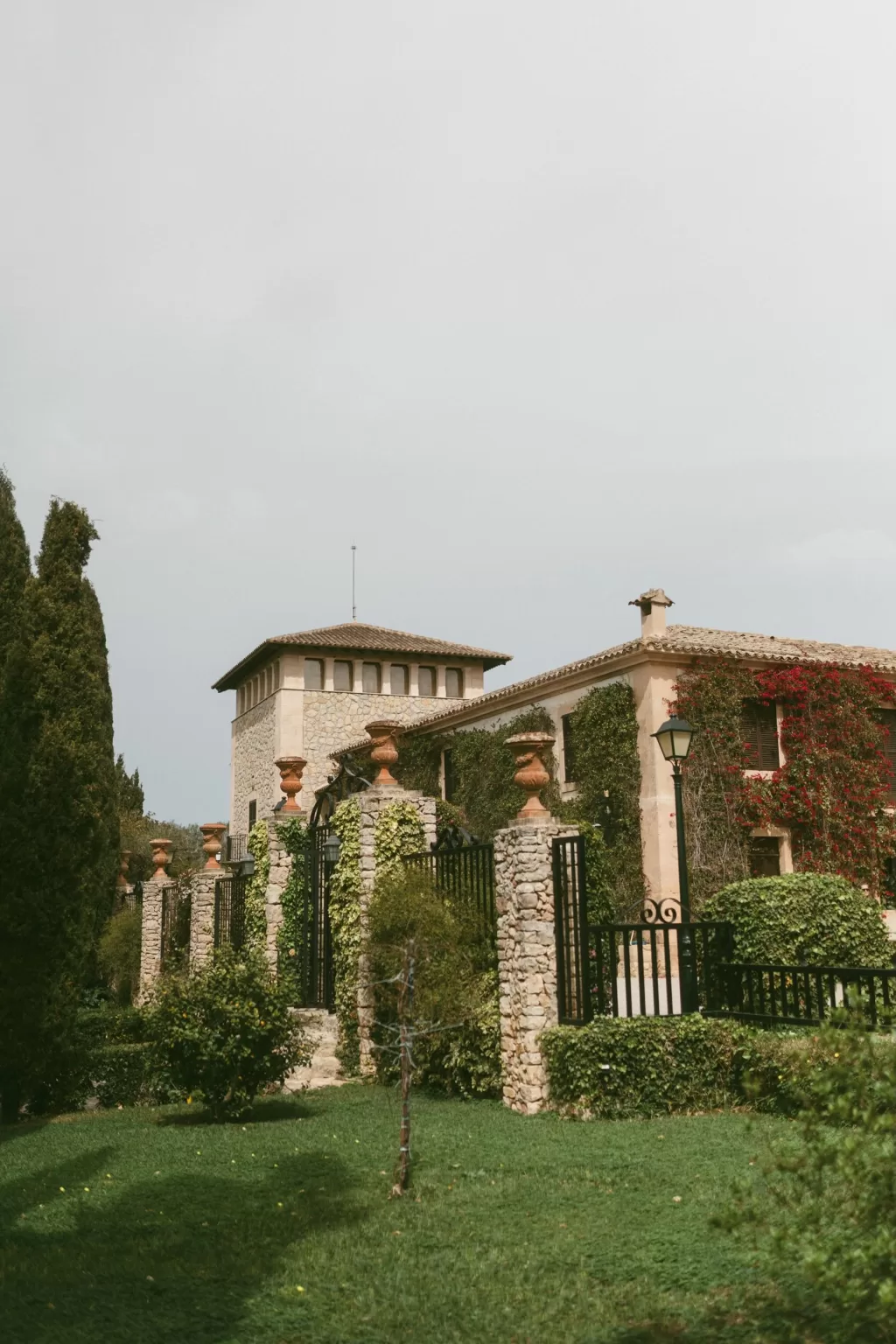 Exterior view of Finca Son Collell’s rustic stone facade and lush garden entrance