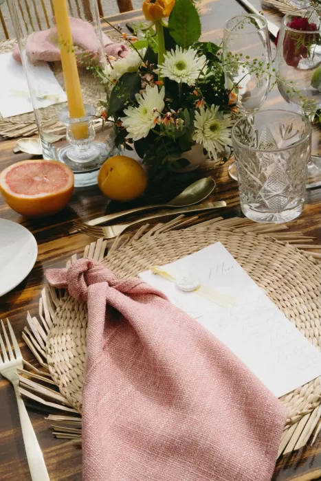 Close-up of the rustic tablescape with citrus fruits, textured linens, and floral arrangements at Finca Son Collell.