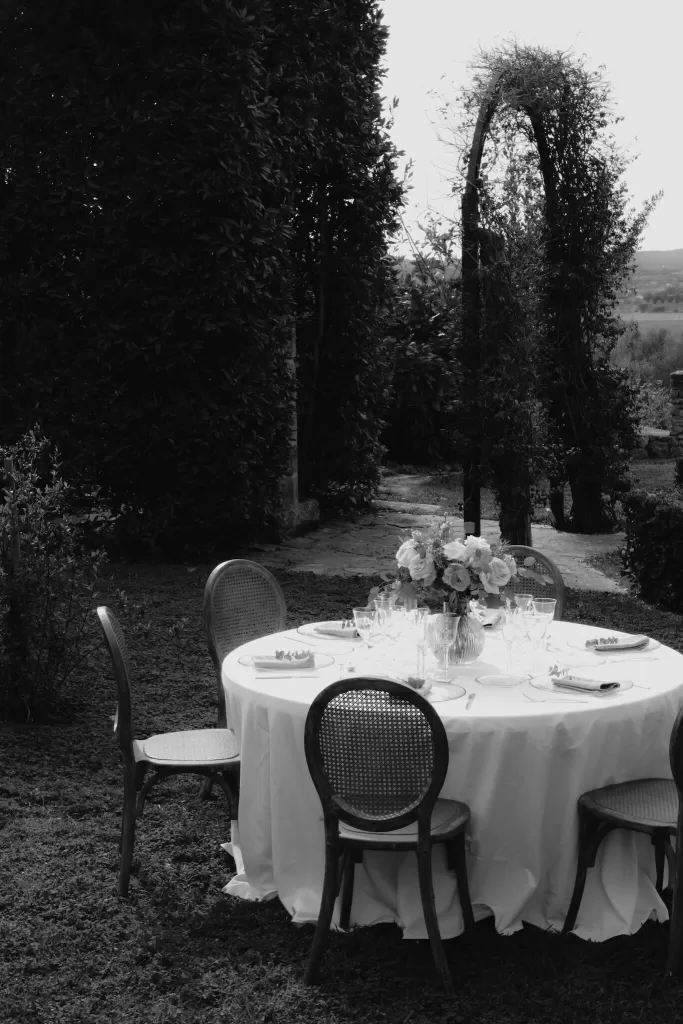 A round table set for an outdoor reception surrounded by manicured greenery at Finca Son Collell.