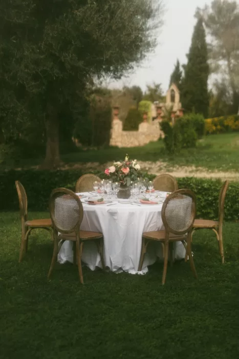 Intimate round table set with floral arrangements under olive trees at Finca Son Collell
