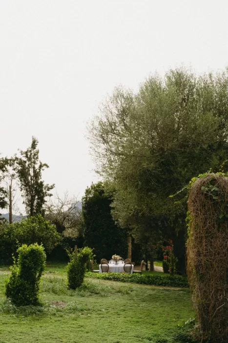 A round wedding table set in the middle of a peaceful green garden at Finca Son Collell, ready for a romantic celebration.