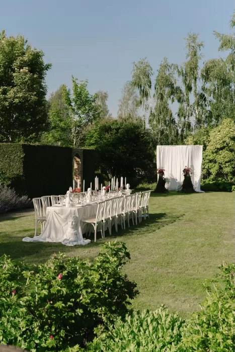 Long outdoor reception table set for guests beside the ceremony altar in Treelove Parkas' tranquil gardens.