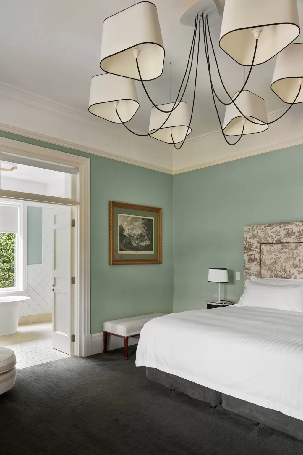 Luxurious guest suite at Le Mas Barossa with mint green walls, patterned headboard, and stylish pendant lighting.