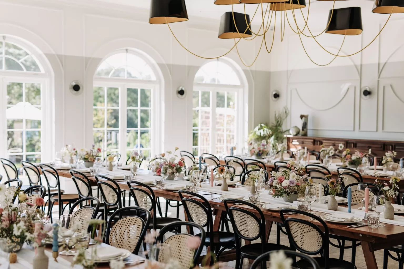 Light-filled reception room with floral tables and arched windows at Le Mas Barossa
