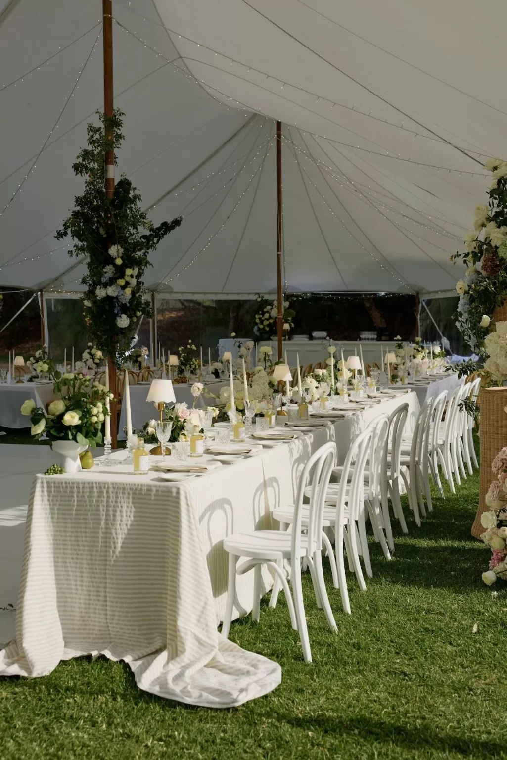 Romantic tented wedding reception at Le Mas Barossa with white florals and string lights.