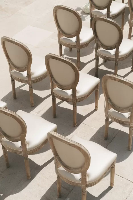 Soft sunlight casting shadows on cream wedding chairs arranged at Mas Torroella.