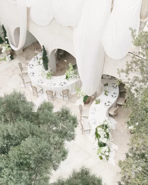 Elegant outdoor wedding setup at Mas Torroella showcasing arched architecture and neutral styling.