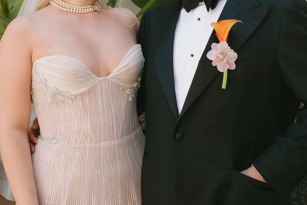 Close-up of stylish bride and groom at Masia Cabellut, showcasing embroidered gown and boutonnière details
