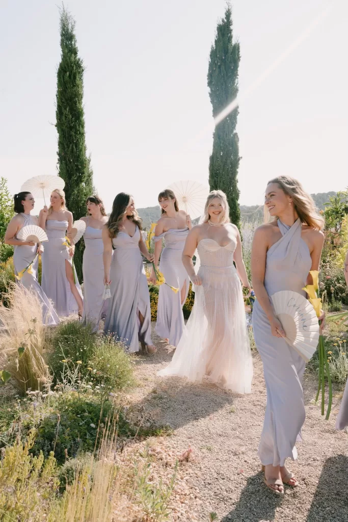 Bride walking joyfully with bridesmaids in soft lilac dresses at Masia Cabellut