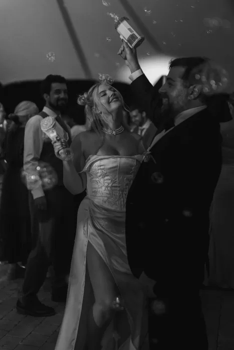 Bride and groom playing with bubble guns on the dance floor at Masia Cabellut, joyful and carefree