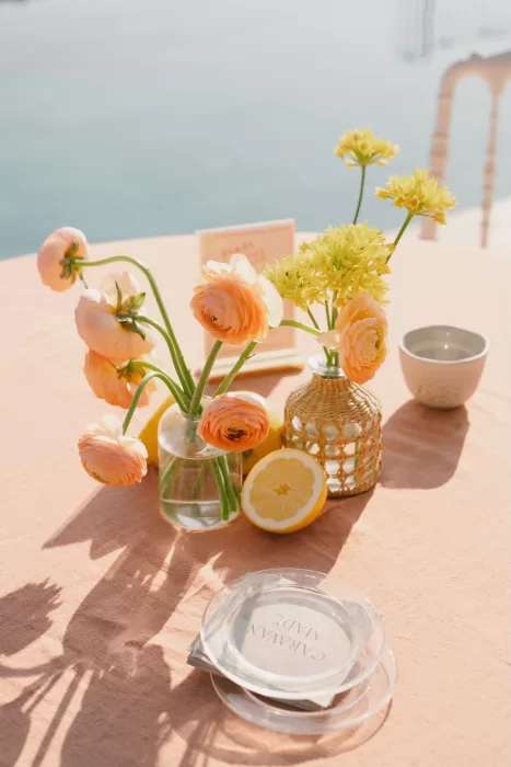 Citrus-themed wedding table at Masia Cabellut with ranunculus, lemons, and ocean views