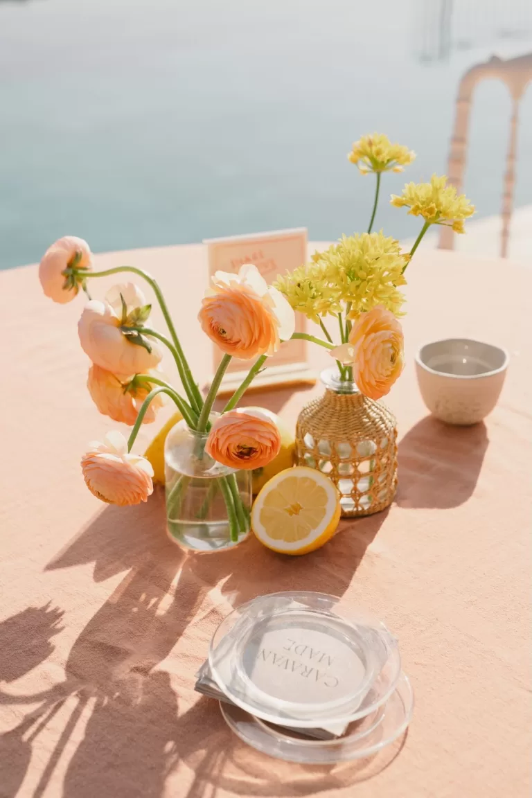 Citrus-themed wedding table at Masia Cabellut with ranunculus, lemons, and ocean views