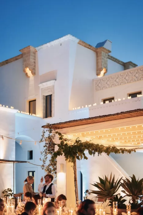 Elegant outdoor wedding reception glowing with candles and fairy lights at Masseria Calderisi