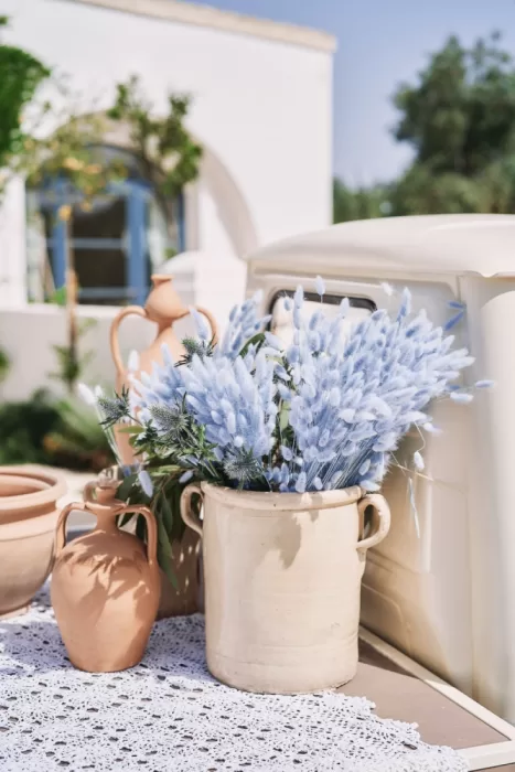Soft pastel-toned dried florals in rustic ceramic vases at Masseria Calderisi