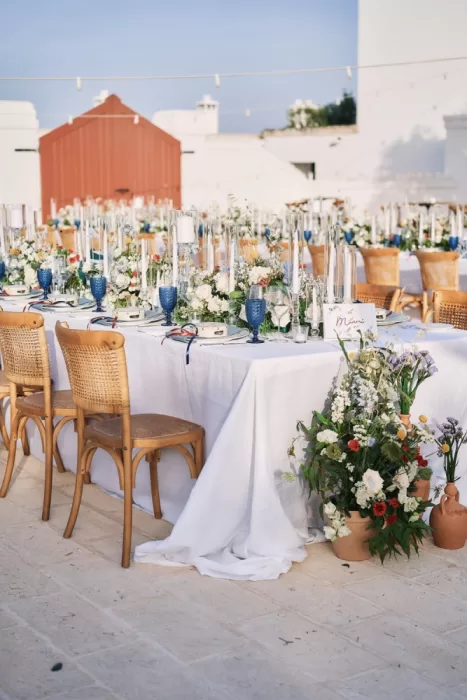 Elegant outdoor wedding table with florals and blue glassware at Masseria Calderisi