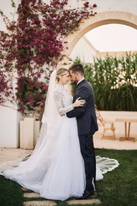 Romantic portrait of the bride and groom framed by bougainvillaea at Masseria Calderisi