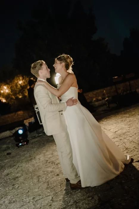 Bride and groom share their romantic first dance under the stars in the courtyard of Masseria Monitilli.