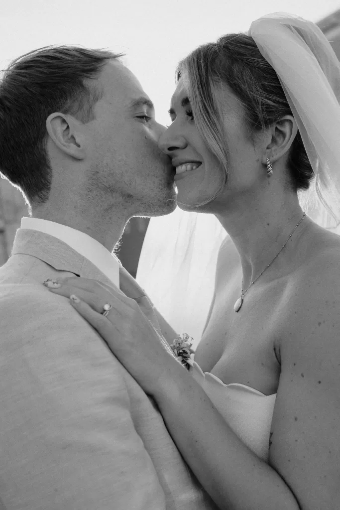 Intimate black-and-white moment of the groom kissing the bride’s forehead at Masseria Monitilli.