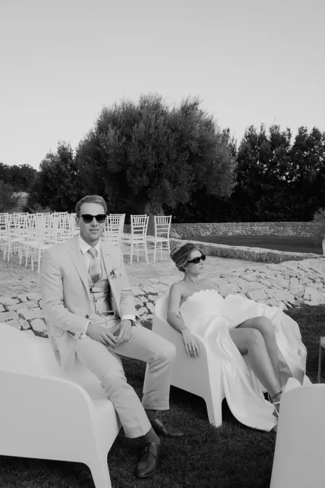 The bride and groom lounging in sunglasses after the ceremony at Masseria Monitilli, exuding effortless style and relaxation.