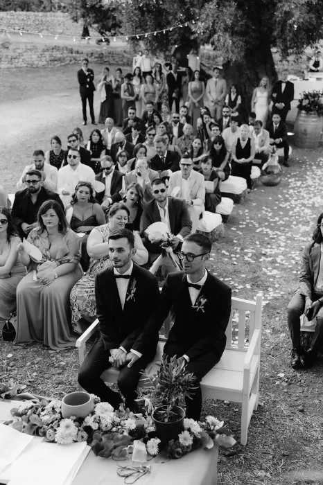 Wedding guests gathered around the grooms during an intimate outdoor ceremony at Masseria Spina