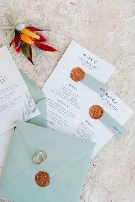 Wedding stationery with wax seals, rings, and boutonnière for Masseria Spina celebration