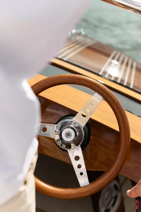 Close-up of a classic wooden boat steering wheel during a stylish wedding arrival at Parco Civico Teresio.