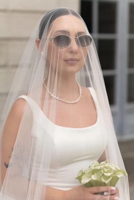 Portrait of bride in sunglasses and veil holding calla lilies at Parco Civico Teresio.