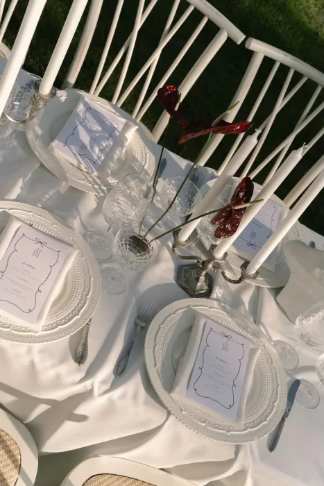Elegant outdoor tablescape at Treelove Parkas with white linens, crystal glassware, and sculptural florals.