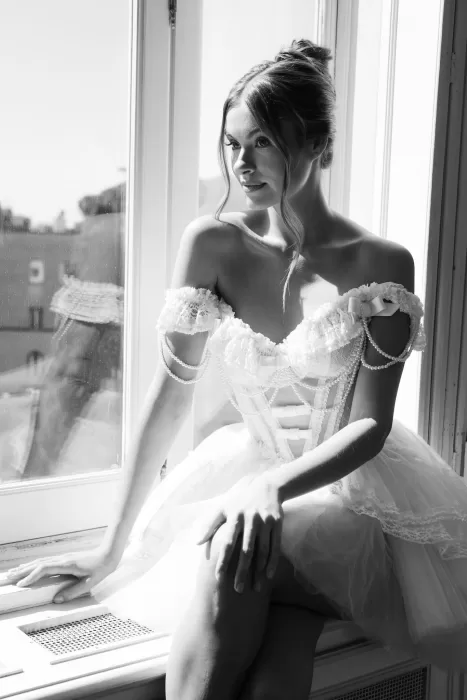 Elegant black and white portrait of bride seated by the window in natural light