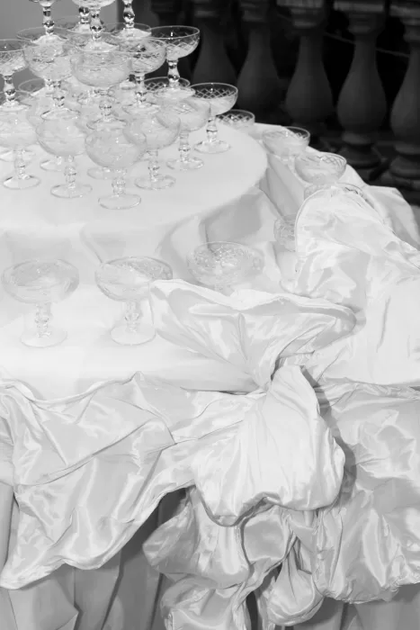 Satin bow detail on tablecloth beneath crystal champagne glasses