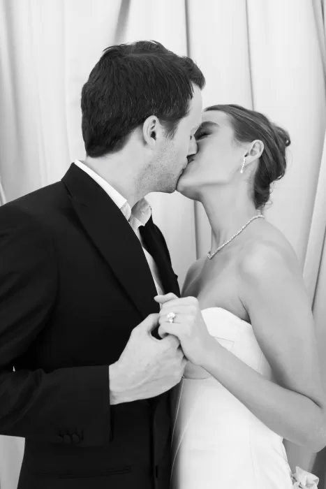 Intimate black-and-white moment of a couple sharing a kiss, highlighting the romance of Villa Aurelia.