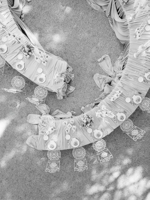 Black and white aerial view of styled wedding tablescape with soft drapery