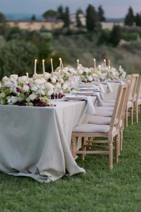 Elegant candlelit wedding reception setup with lush florals on the lawn at Villa Medicea di Lilliano.