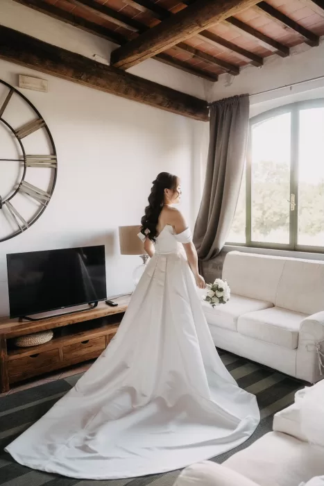Bride holding bouquet and gazing out the window before the ceremony at Villa Olimpia