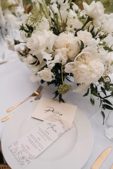 Elegant place setting with floral menu card and gold cutlery at Villa Olimpia wedding reception.