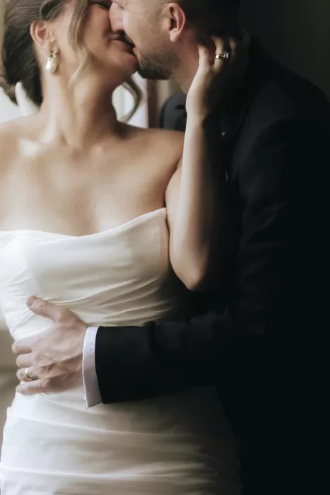 Bride and groom share a tender kiss by the window at Villa Ravano, wrapped in soft, romantic light.