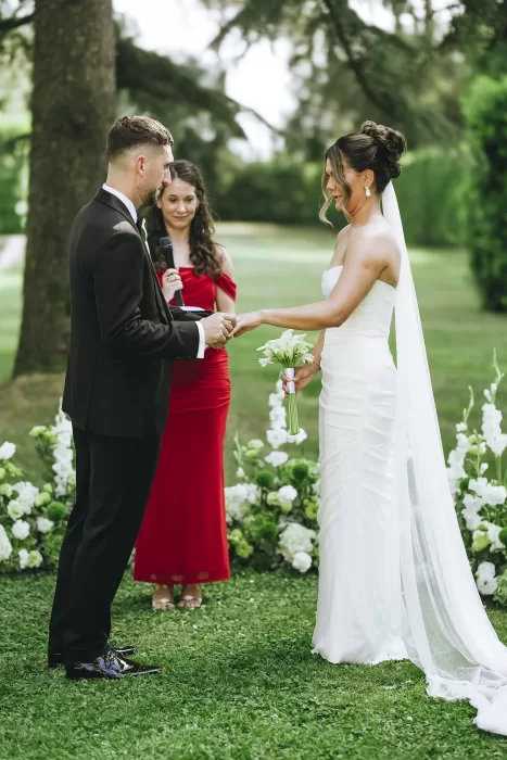 Bride and groom exchange rings in an intimate garden ceremony framed by greenery at Villa Ravano.