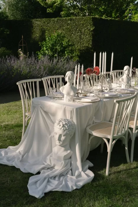 Artistic wedding tablescape featuring classical busts, taper candles, and draped fabric at Treelove Parkas.