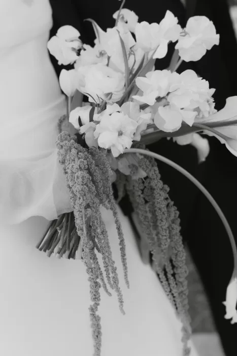 Close-up of the bride’s bouquet with white blooms and cascading greenery at Baja Luna.