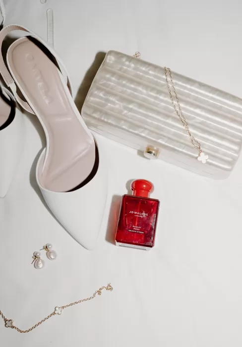 Elegant flat lay of bridal shoes, perfume, and jewelry at Middleton Lodge.
