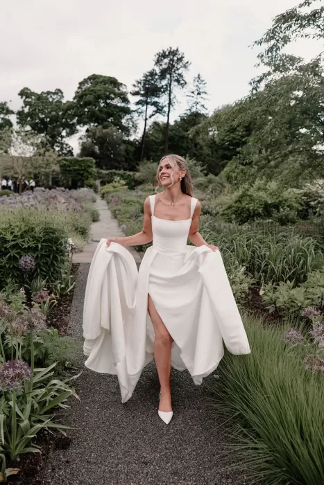 Smiling bride walking through the blooming gardens at Middleton Lodge.