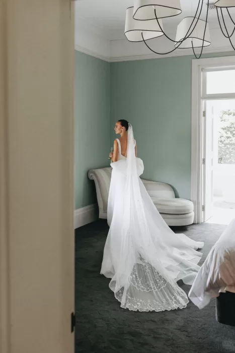 Timeless bridal portrait by the window with trailing veil in a serene room at Le Mas Barossa.