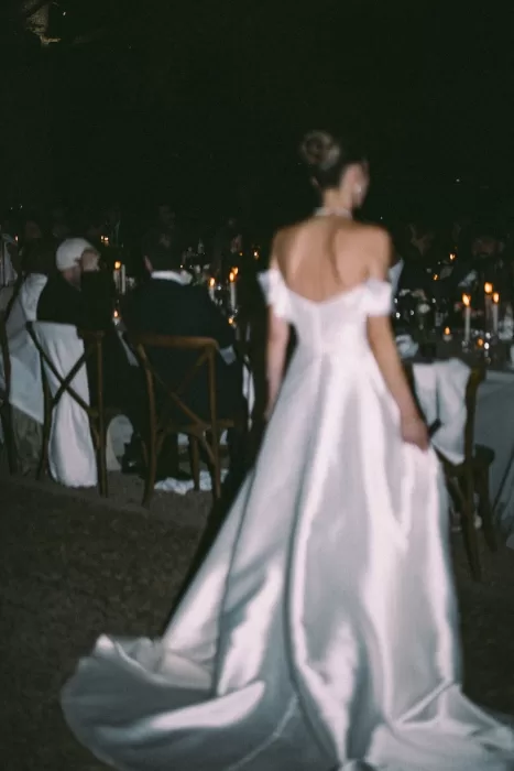 Blurred image of the bride walking toward guests at a romantic candlelit dinner at Cigarral de la Mercedes.