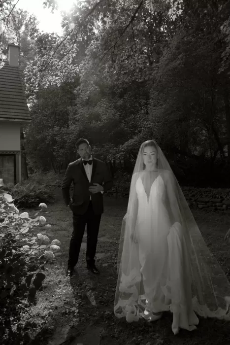 Black and white portrait of the bride and groom among trees at Château Ste. Agnès, capturing a cinematic, timeless mood.