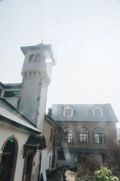Sunlight hitting the romantic castle-like tower of Château Ste. Agnès, capturing its fairytale charm.